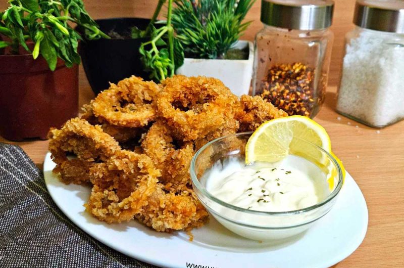 General concept image: "Calamariere, a seafood chef skilled in preparing calamari dishes within Mediterranean cuisine." Food-focused image: "Calamariere presenting a plate of fried calamari rings with lemon and dipping sauce." Cultural image: "Calamariere representing coastal cuisine and seafood culture in Mediterranean traditions." Cooking process image: "Calamariere cleaning and preparing fresh squid for traditional calamari recipes." Restaurant/branding image: "Seafood restaurant branding with the name Calamariere highlighting squid specialties."